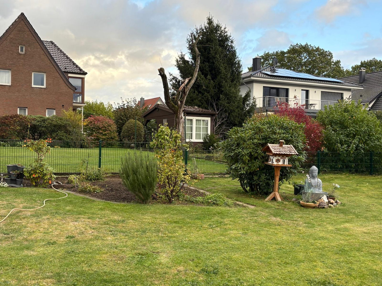Garten mit Rasenflächen, Bäumen und gepflegten Gehölzen